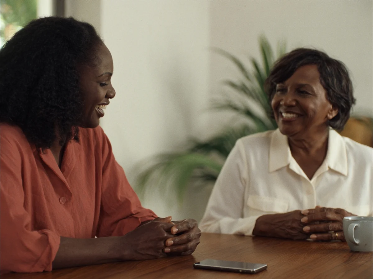 An AI-generated mother and adult daughter sharing a conversation at home