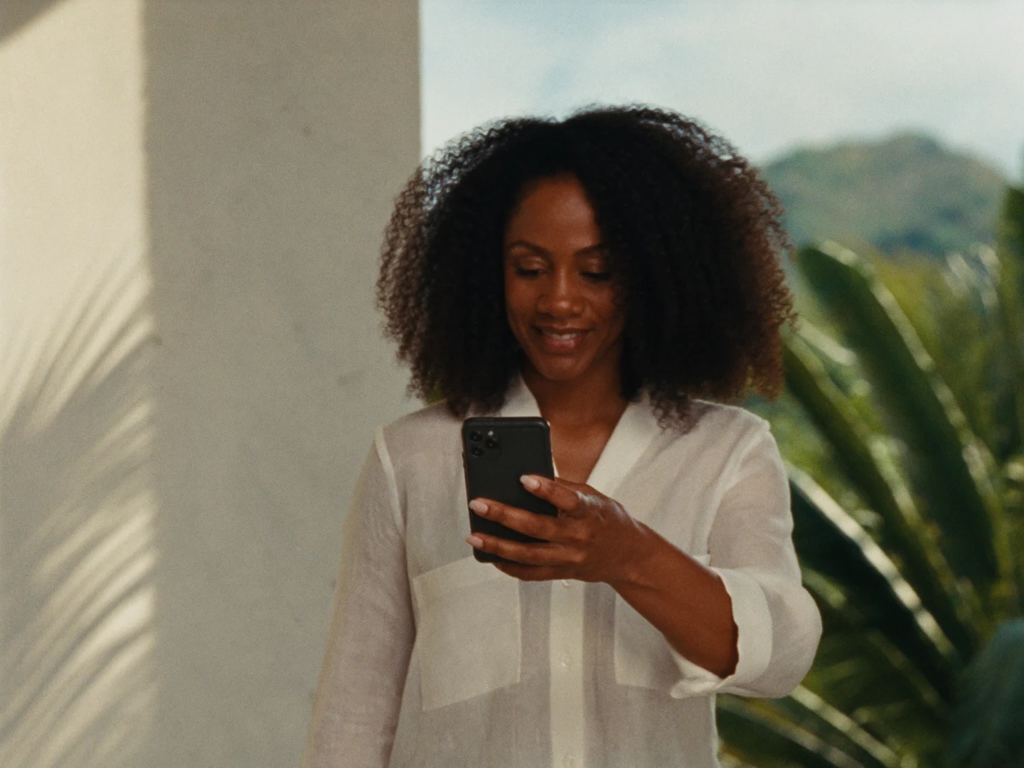 A Trinidadian woman enjoying a peaceful moment on her sunny home veranda